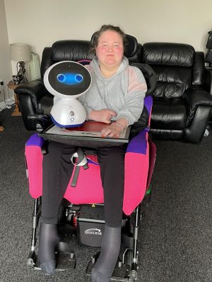 Lady in a wheelchair with a Genie robot